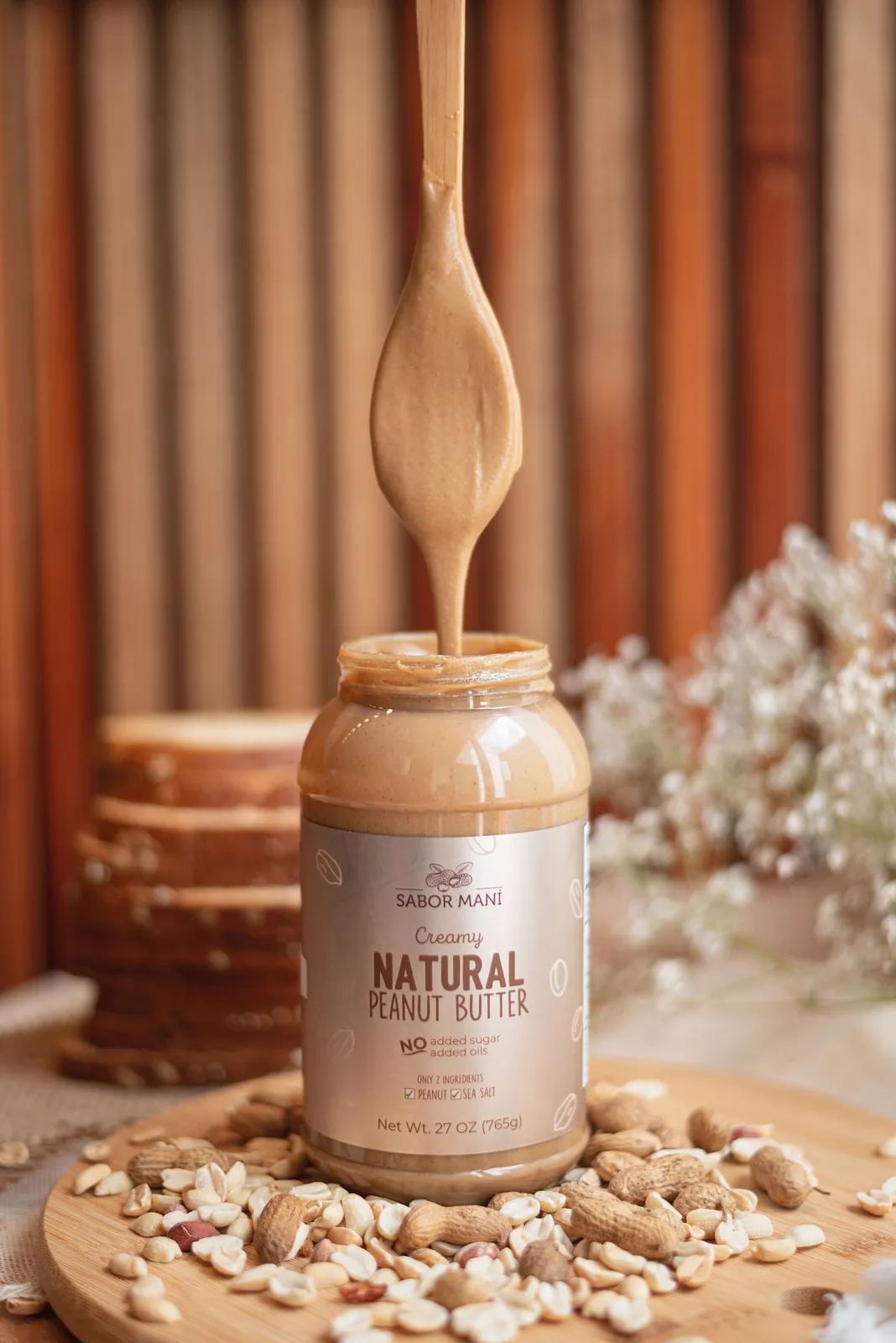 Cuchara escurriendo crema de cacahuate natural Sabor Maní sobre el frasco